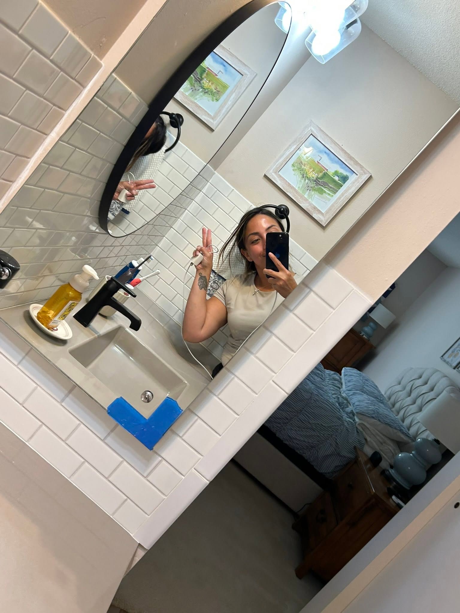 GC cleaner flashing a peace sign in the mirror of a freshly cleaned subway-tile bathroom