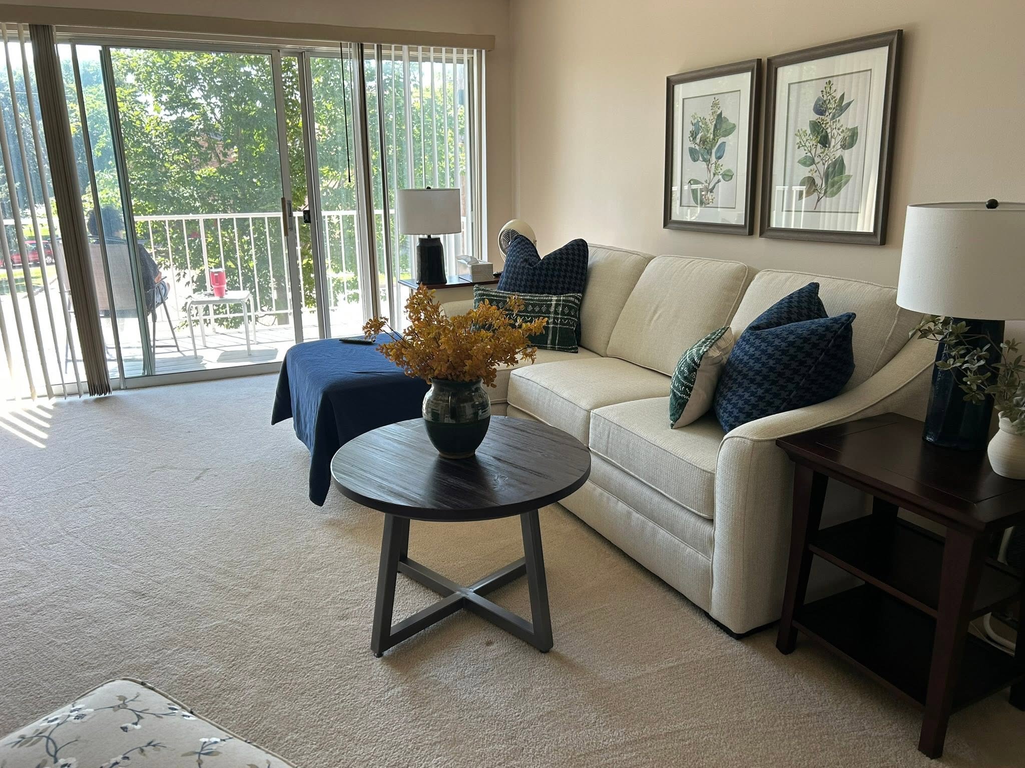 A living room GC Cleaning finished: cream sofa with the cushions set, wiped coffee table, and freshly vacuumed carpet